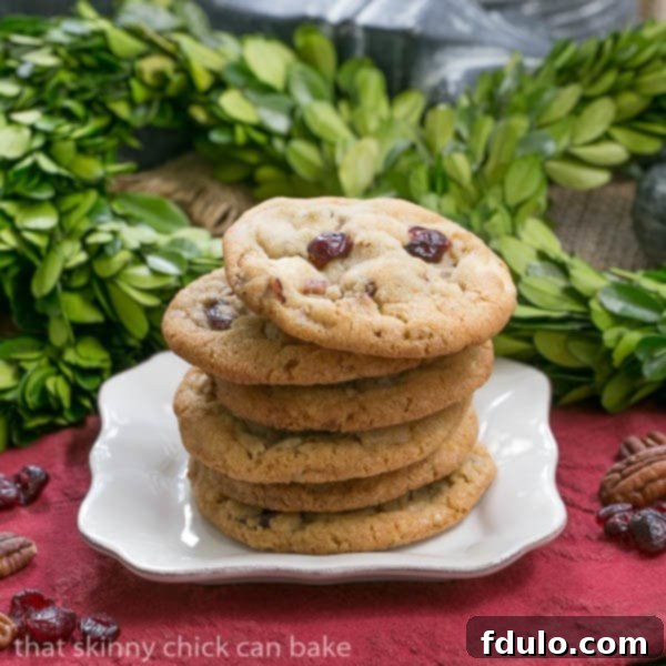 Cranberry, White Chocolate, Crystallized Ginger Cookies stacked on a white plate, ready to be served.