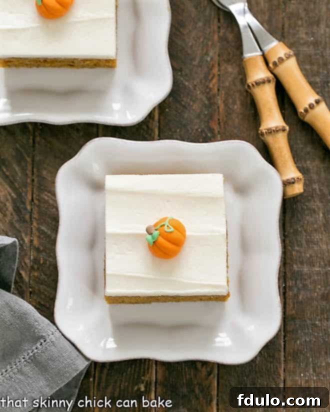 Killer Pumpkin Bars with Cream Cheese Frosting - Guaranteed the BEST Pumpkin Bars you'll ever taste! Overhead view of 2 Killer Pumpkin Bars with Cream Cheese Frosting on square white plates, ready to be enjoyed.