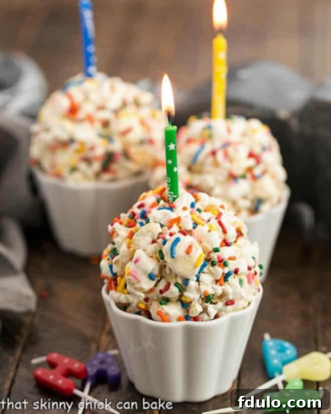 Easy Marshmallow Popcorn Balls in white ramekins, some topped with lit candles, arranged for a festive occasion.