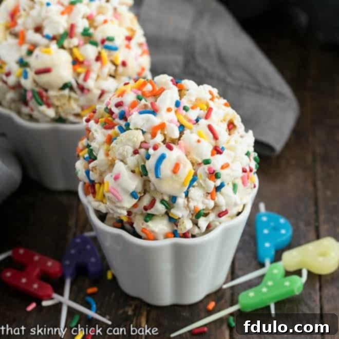 Two popcorn balls in white ramekins surrounded by colorful candles, ready for a celebration
