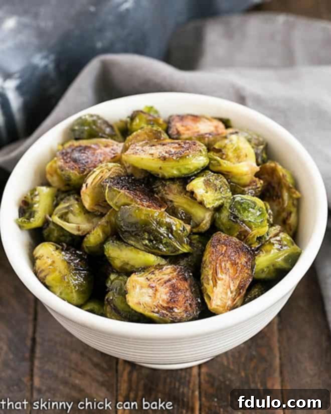 Roasted Brussels Sprouts Recipe - Turn these once dreaded vegetables into one amazing side dish by roasting a tossing in a vinaigrette Overhead view of honey balsamic brussels sprouts in a white bowl, ready to serve.