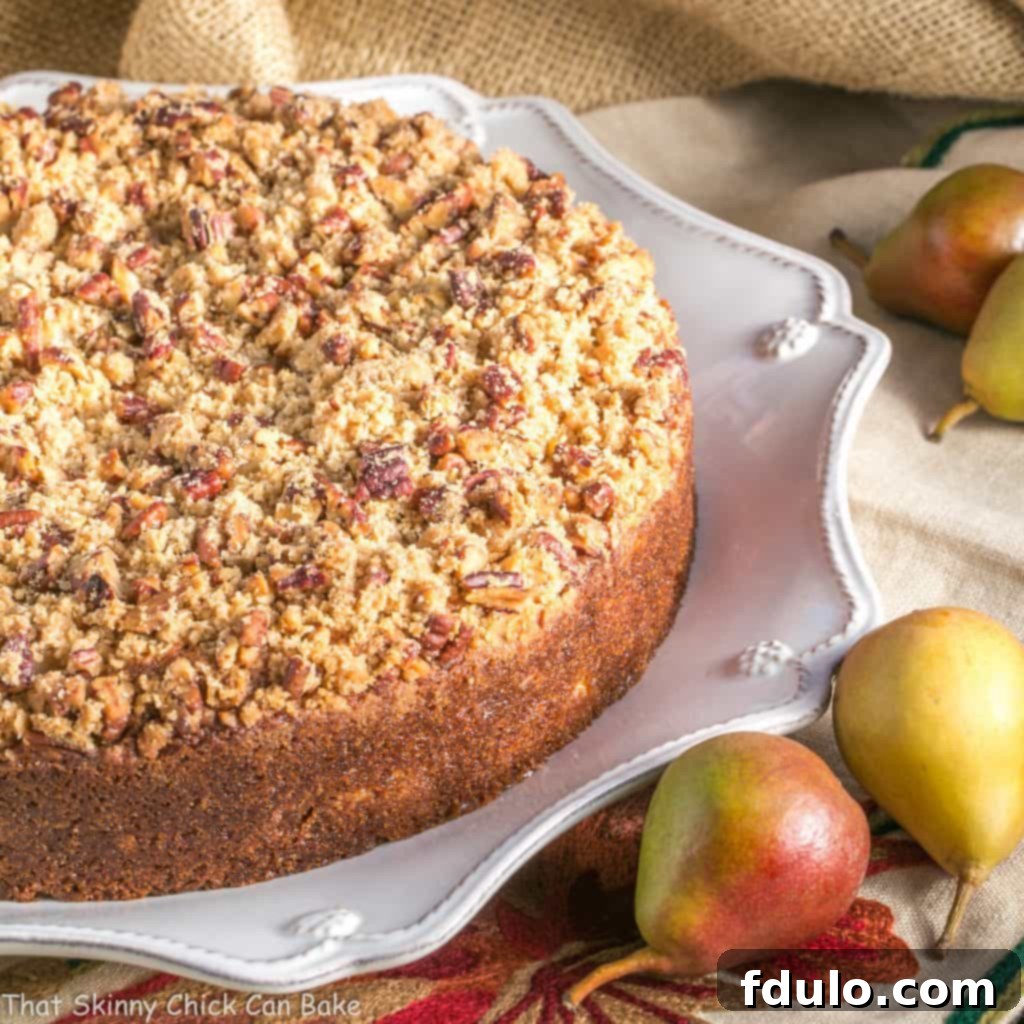 Pear Streusel Coffee Cake on a white platter with fresh pears, ideal for sharing
