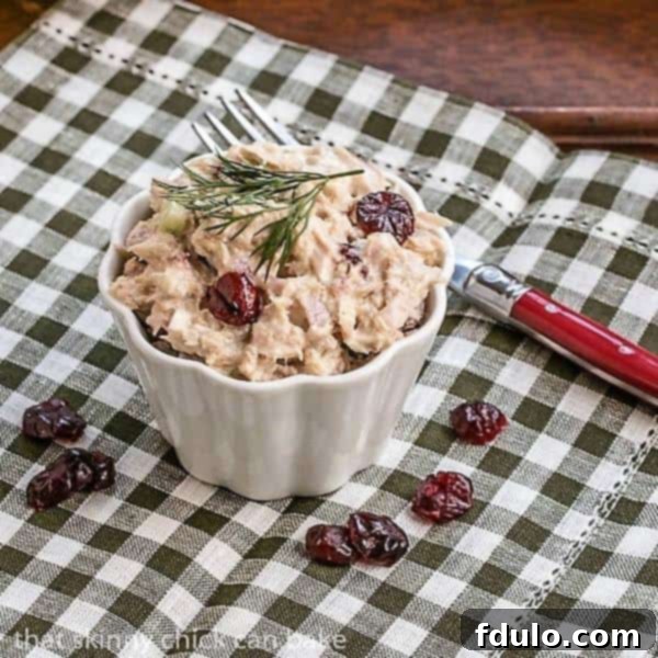 A serving of Tuna, Cranberry, Pecan Salad in a small white ramekin, showcasing its rich texture and colorful ingredients, perfect for a light meal or appetizer.