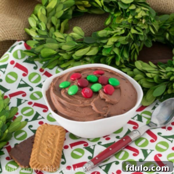 Easy Brownie Dip in a white bowl with a festive holiday napkin, accompanied by two cookie dippers, perfect for a cozy gathering or party.