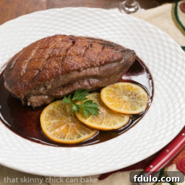 Pan Seared Duck Breast on a white plate with citrus slices.