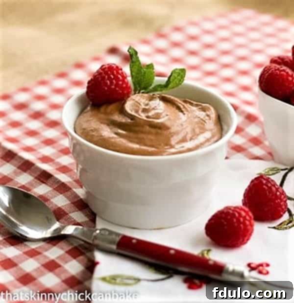 Decadent Grand Marnier Chocolate Mousse 4 A serving of Classic French Chocolate Mousse with Grand Marnier in a white ramekin, with a small red-handled spoon digging in.