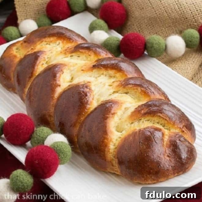 Beautifully golden-brown loaf of authentic Swiss Butter Braid (Butterzopf) on a pristine white platter, showcasing its intricate braiding.