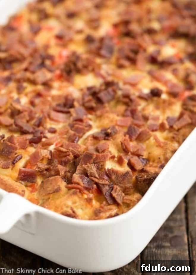 The full Easy Bacon and Egg Strata nestled in a white ceramic casserole dish, ready to be served.