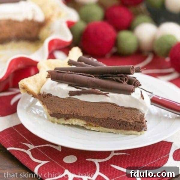 A perfectly sliced Black Bottom Chocolate Mousse Pie showcasing its decadent layers: crust, ganache, mousse, and whipped cream, adorned with chocolate curls.
