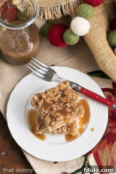 Close-up of a Caramel Apple Streusel Bar on a white ceramic plate with a red handled fork, highlighting its crumbly topping and rich caramel.