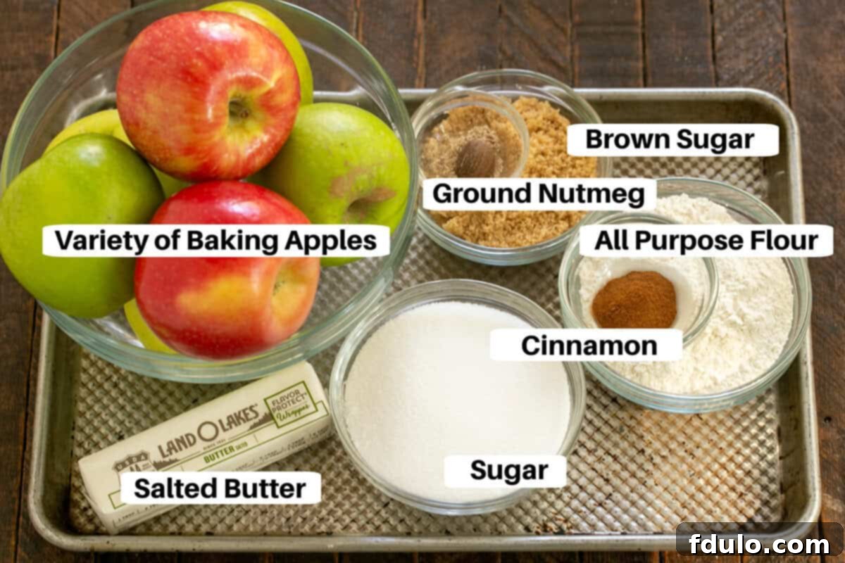 Apple crisp ingredients with labels on a metal sheetpan, including apples, sugar, flour, butter, and spices.