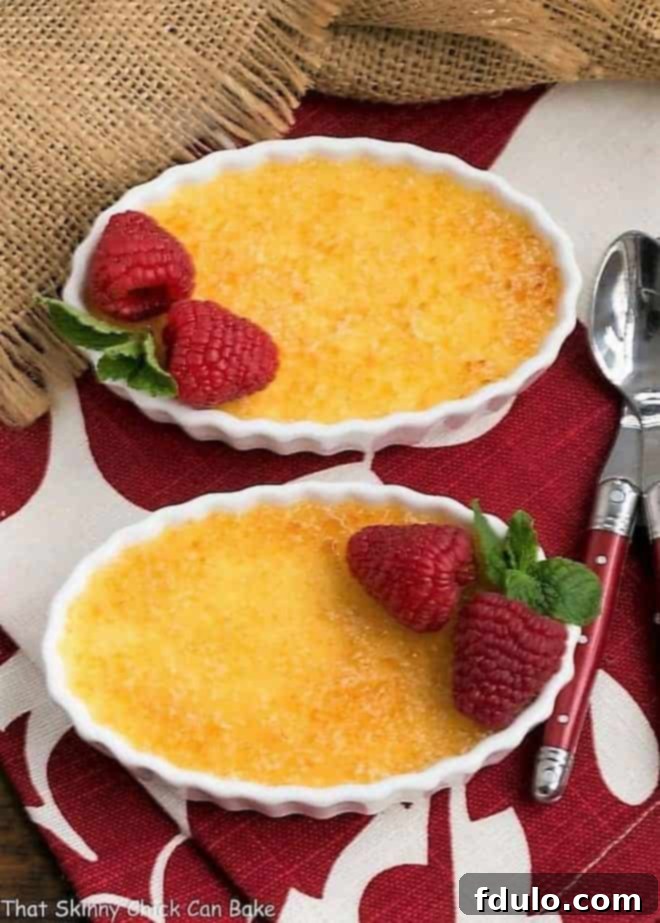 Two Classic Crème Brûlée with red handled spoons..
