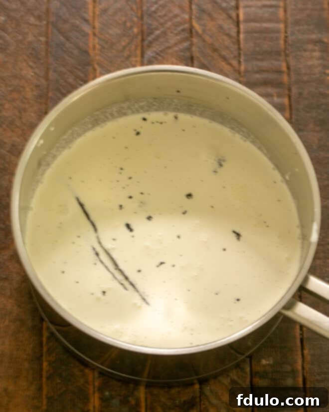 Heavenly Crème Brûlée Perfection 3 Cream, vanilla pod, vanilla seeds, sugar, and salt heating in a saucepan.