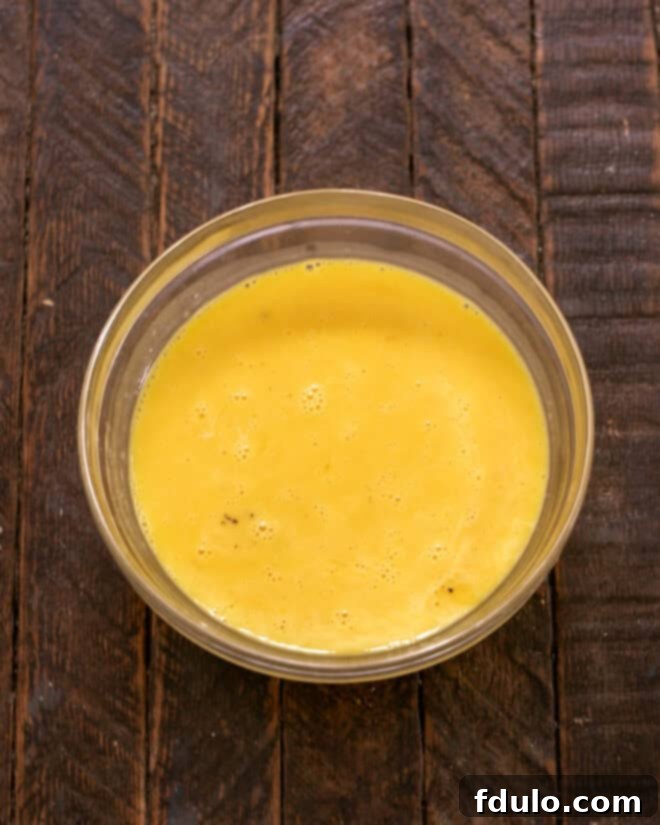 Whisked eggs in a Pyrex bowl.