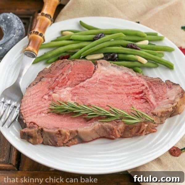 A succulent slice of rare Classic Prime Rib on a white plate, showcasing its vibrant red center and browned crust.