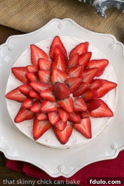 An inviting overhead view of a beautifully prepared Strawberry Vanilla Cream Pie, showcasing its artistic topping of fresh, sliced strawberries arranged in a delightful pattern.