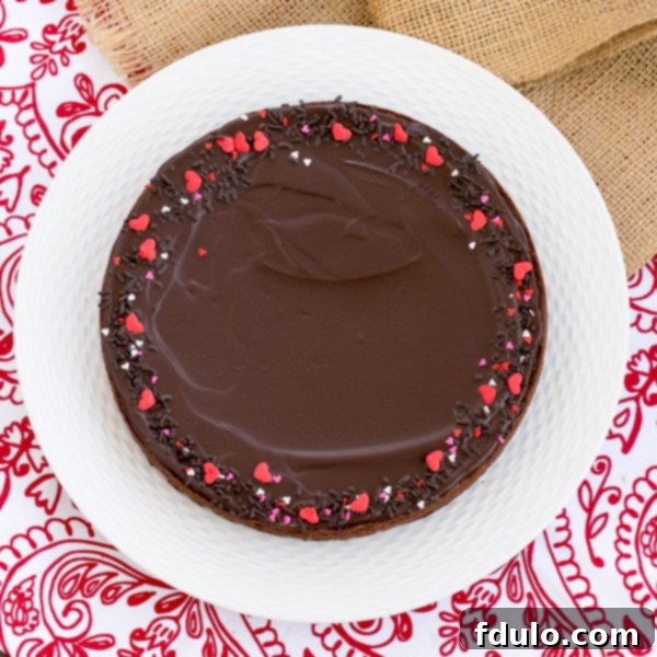 Decadent Ganache Topped Truffle Brownies artfully arranged on a white ceramic plate, showcasing their rich, dark chocolate glaze.