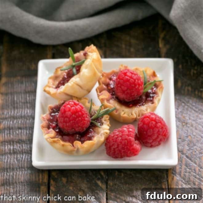 Delicate Raspberry Brie Bites arranged artfully on a square white plate, ready to be served as an appetizer.