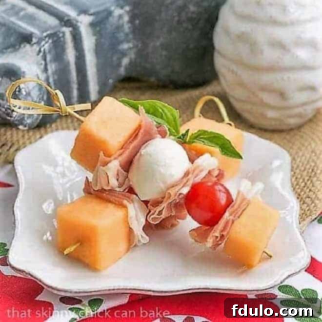 Melon and Prosciutto Skewers on a small white appetizer plate, showcasing the vibrant ingredients.