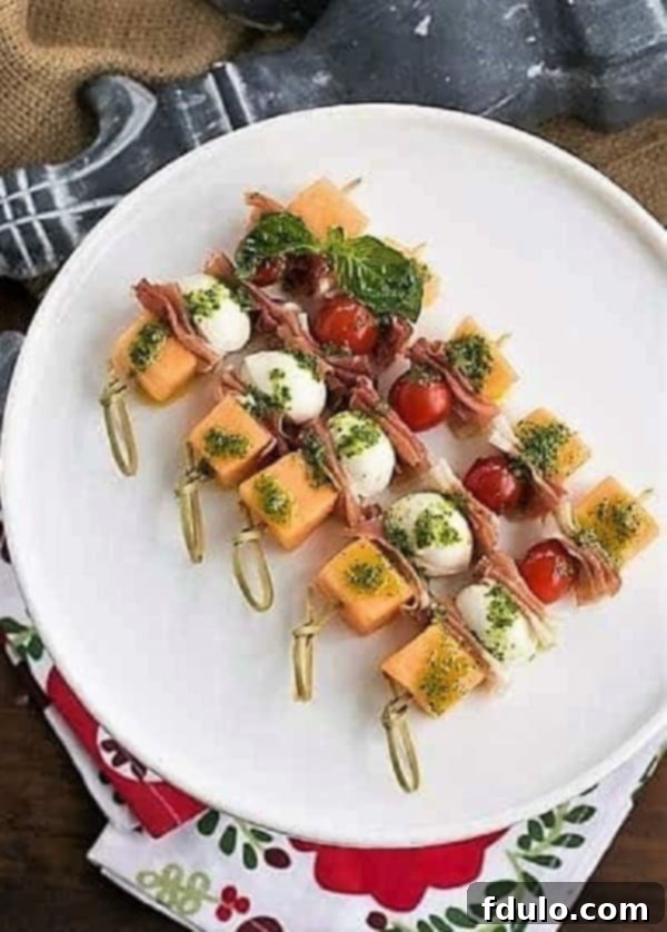Melon and Prosciutto Skewers neatly arranged on a pristine white cake stand, ready for serving.