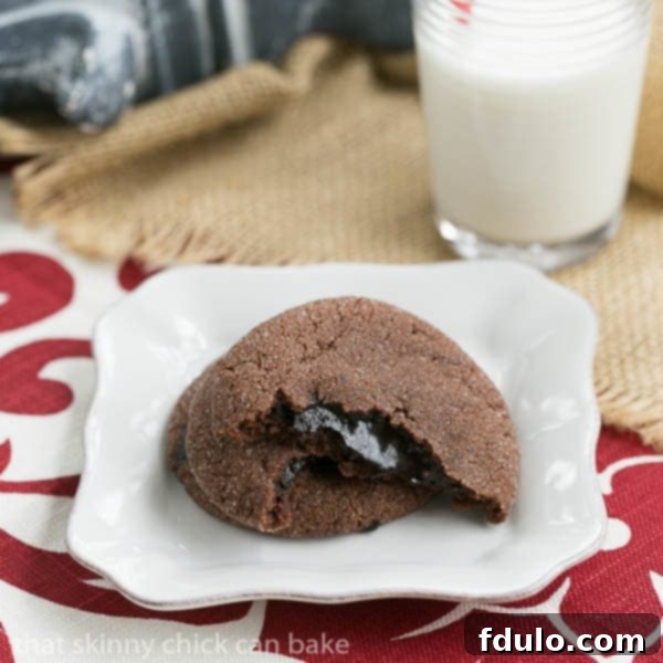 Freshly baked Chocolate Lava Cookie broken in half, revealing its warm, gooey fudge filling cascading from the center.