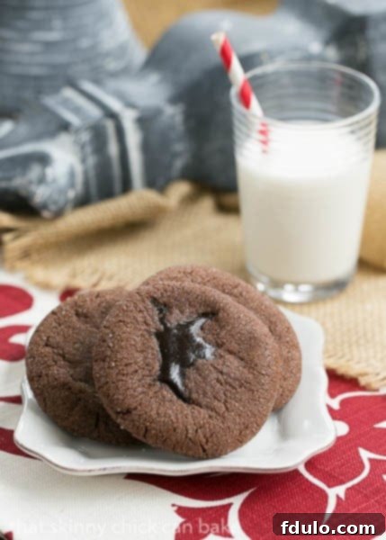 A plate of warm, ready-to-eat Chocolate Lava Cookies, perfectly paired with a refreshing glass of milk, creating a classic dessert scene.