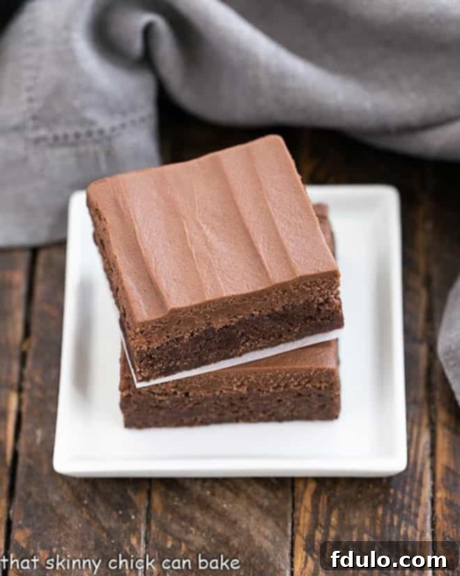 Frosted Brownies Recipe stacked on a small white plate