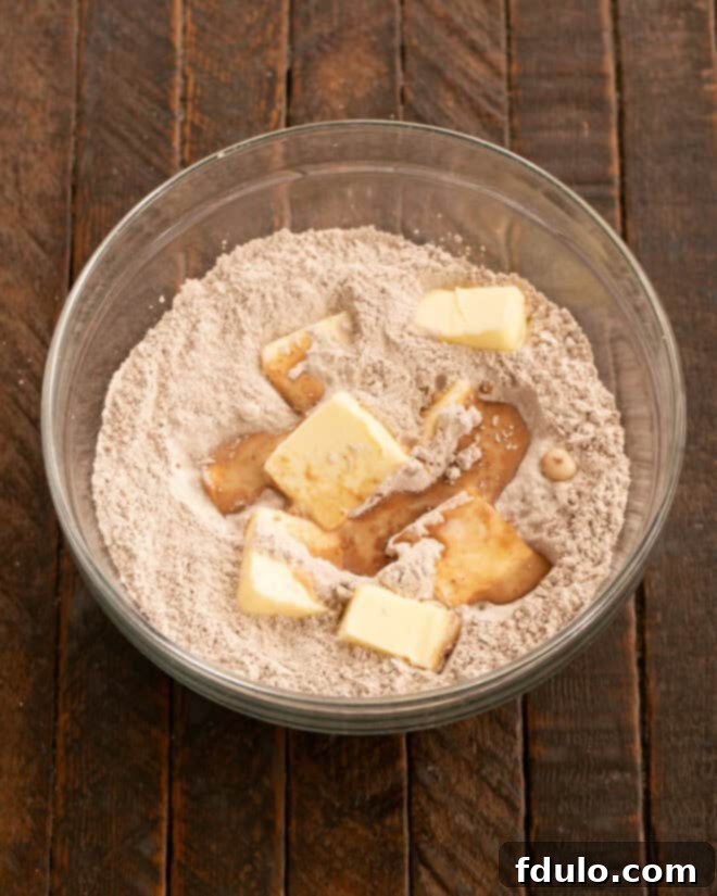 Mixing ingredients for chocolate buttercream frosting in a stand mixer.