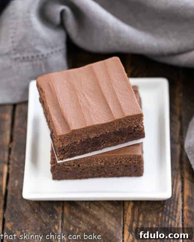 A frosted brownie being cut into squares.