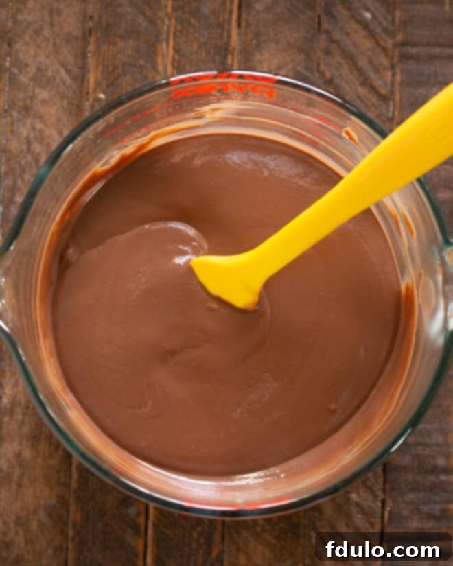 Pouring the finished chocolate pudding into individual serving dishes.