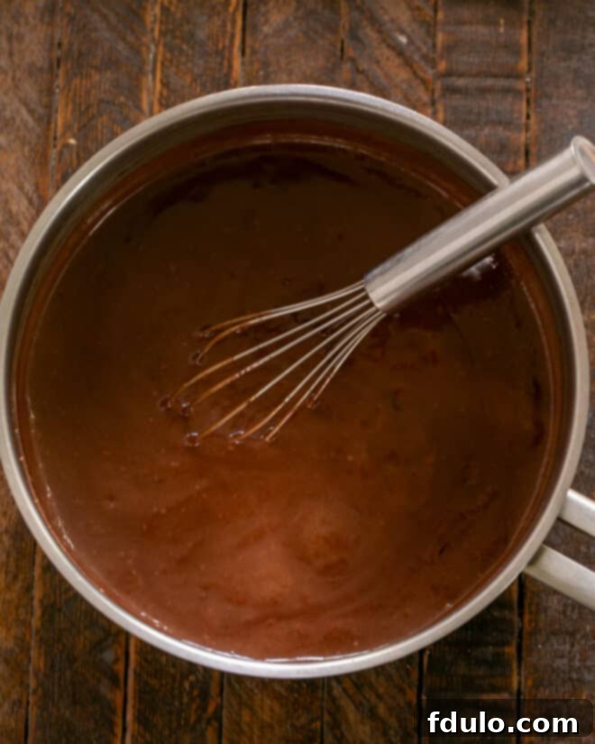 Cooking the chocolate pudding mixture until it thickens to the desired consistency.