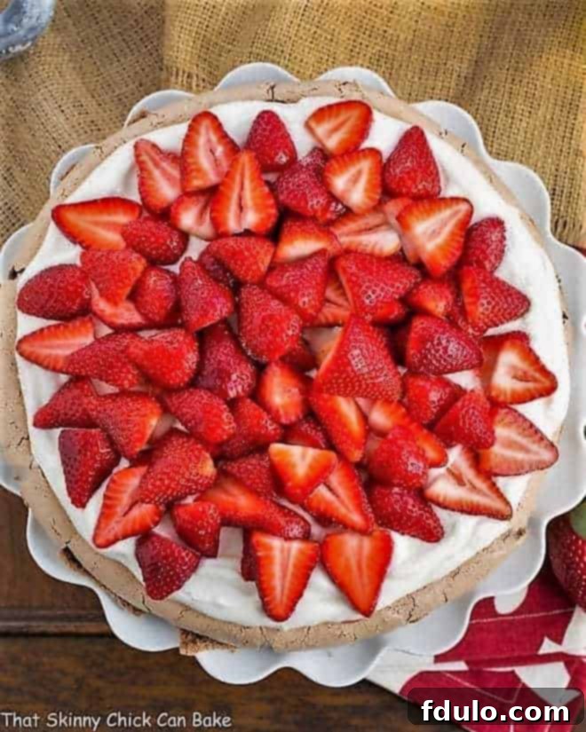Strawberry Topped Chocolate Pavlova Recipe - A chocolate meringue topped with mascarpone cream and luscious strawberries Strawberry Topped Chocolate Pavlova overhead shot on a ruffled white cake plate