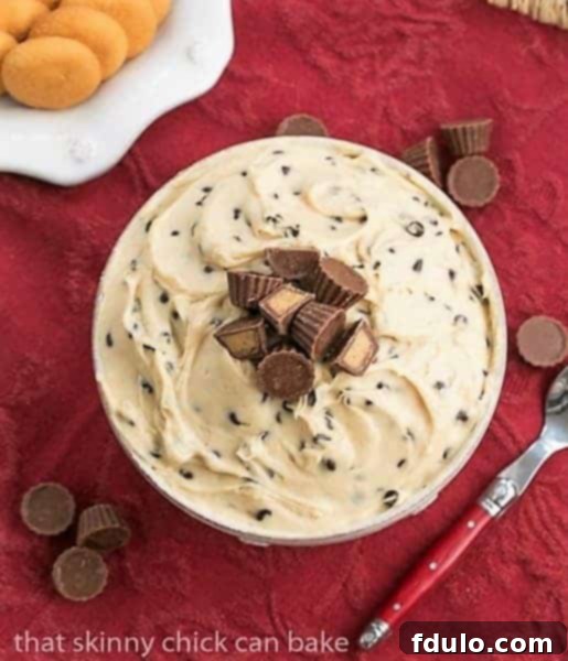 Overhead view of Tagalong dip in a serving bowl topped with mini Reeses peanut butter cups
