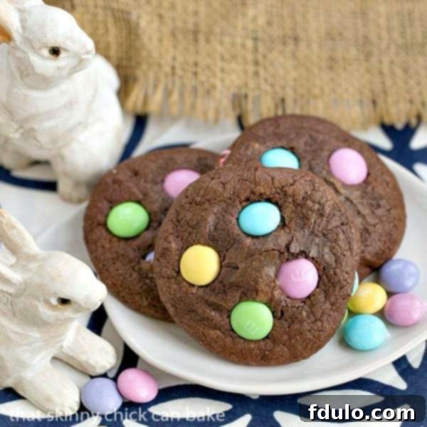 Easter Brownie Cookies - Chewy chocolate cookies speckled with leftover Easter candy Easter Candy Brownie Cookies on a white tray with M&Ms, showcasing their rich chocolate color and vibrant candy toppings.