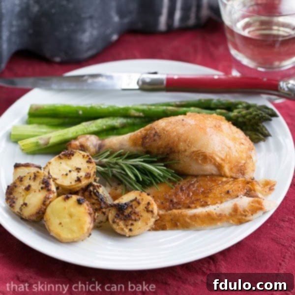 A perfectly portioned serving of Classic Roast Chicken with Mustard Potatoes on a white dinner plate, ready to enjoy.