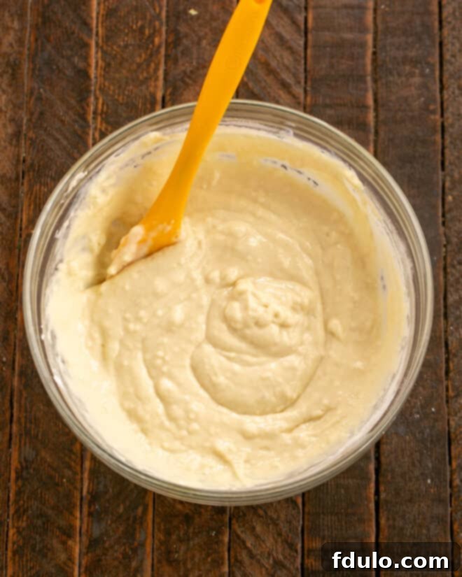Dry ingredients (flour, baking soda, baking powder) combined in a bowl, with a separate bowl containing the wet buttermilk mixture, and a small dish of melted butter nearby.