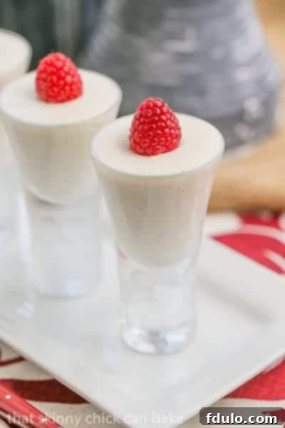 Vanilla Bean Cheesecake Shooters elegantly arranged on a sleek white ceramic tray, emphasizing their gourmet appeal and portion-controlled size.
