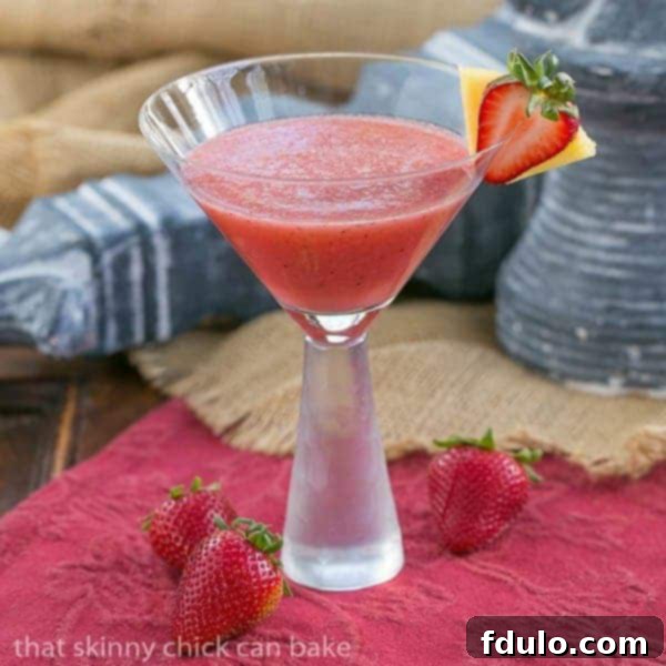 Hawaiian Sunset Cocktail - Strawberries, pineapple and rum form an irresistible tropical drink Hawaiian Sunset Cocktail garnished with a strawberry and pineapple slice