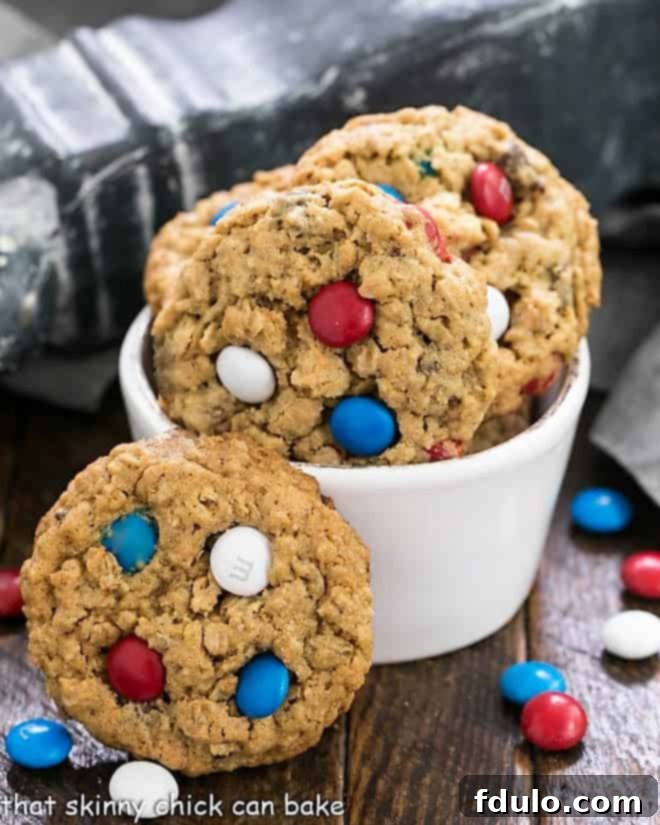 Peanut Butter Oatmeal Cookies with M&Ms in a small white bowl surrounded by patriotic colored M&Ms, showcasing a delightful texture.
