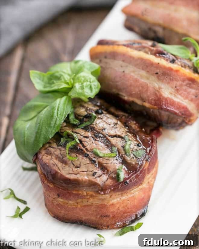 Grilled Steak with Garlic Butter wrapped in bacon on a white platter, ready to be served.