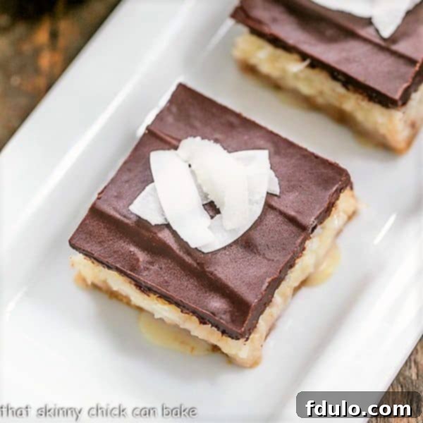 Garnished Coconut Chocolate Bars with shaved coconut, arranged artfully on a white serving tray.