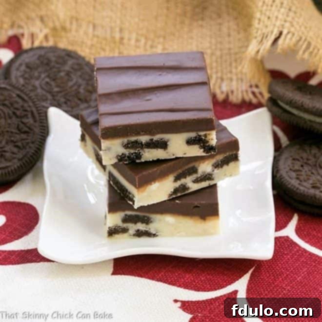 Oreo Double Decker Fudge stacked artfully on a small white plate, ready to be enjoyed.