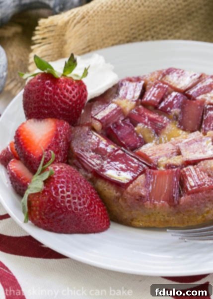 Rhubarb Upside Down Brown Sugar Cake - A slice of the cake served with strawberries and creme fraiche