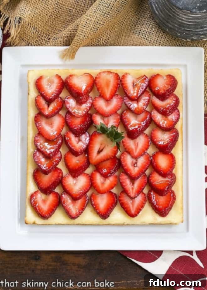 Freshly baked Strawberry Cheesecake Bars on a square white platter, ready to be served.