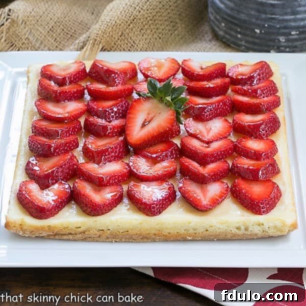 Delicious Strawberry Cheesecake Bars generously topped with vibrant sliced berries.