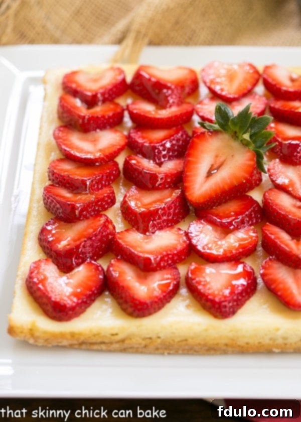 A close-up view of perfectly layered Strawberry Cheesecake Bars on a white ceramic platter.