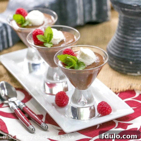 Elegant chocolate mousse served in martini glasses, arranged on a white ceramic tray, perfect for a sophisticated dessert.