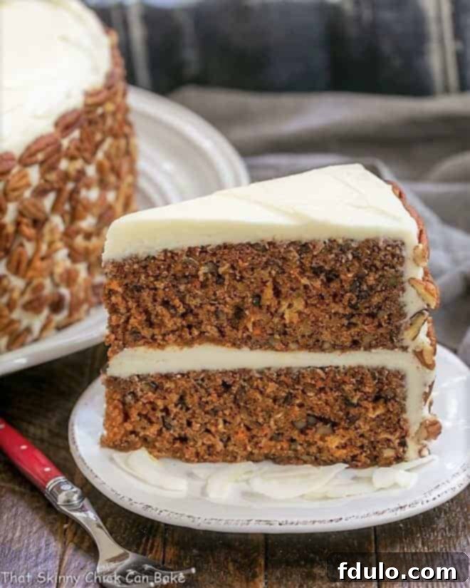 Moist Carrot Cake Recipe with Pineapple, Coconut and Pecans - Dense, delicious and loaded with flavor and texture, then topped with decadent cream cheese frosting Slice of Classic Carrot Cake on a white dessert plate, showcasing its moist texture and rich ingredients.