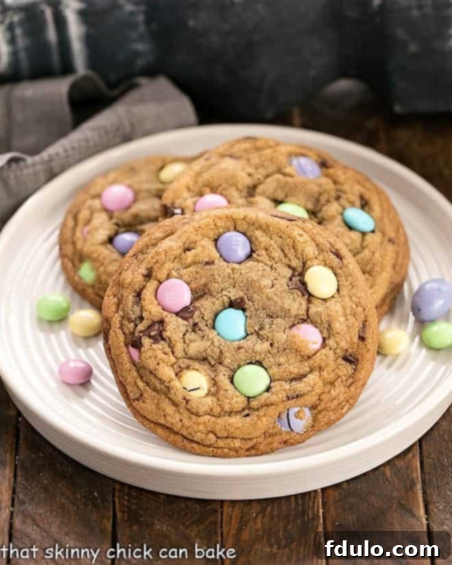 Brown Butter Easter Cookies - Marvelous cookies to celebrate Easter or use up that extra candy! 3 Brown Butter Easter Cookies on a rimmed white place surrounded by pastel M&M's, showcasing their delightful texture.