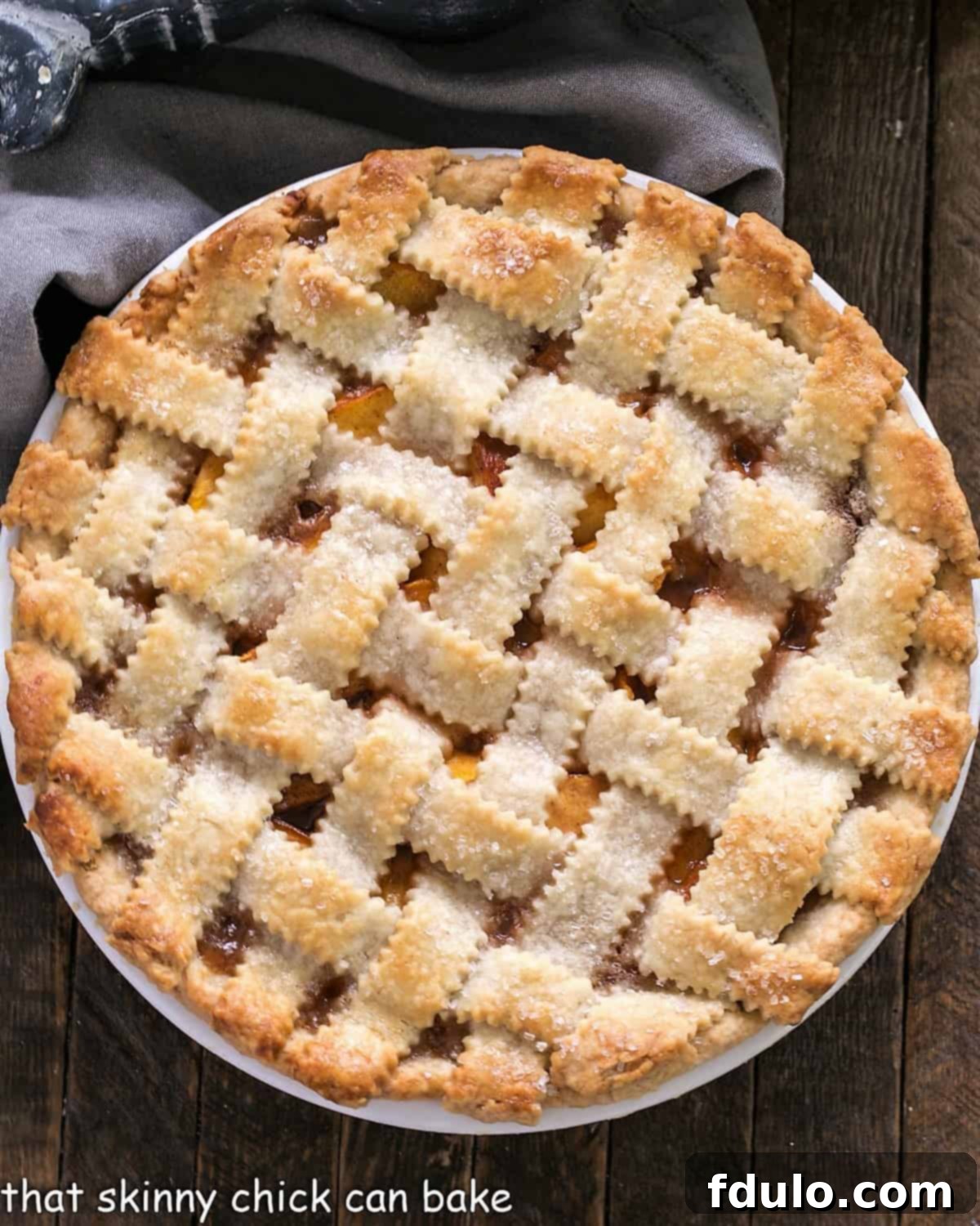 Overhead view of a Classic Peach Pie with a lattice crust, showcasing golden-brown crust and bubbling peach filling.